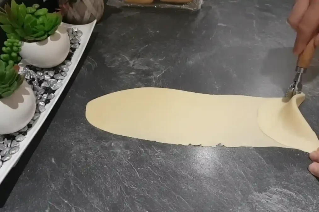 Découpe de la pâte des cornes de gazelle avec une roulette