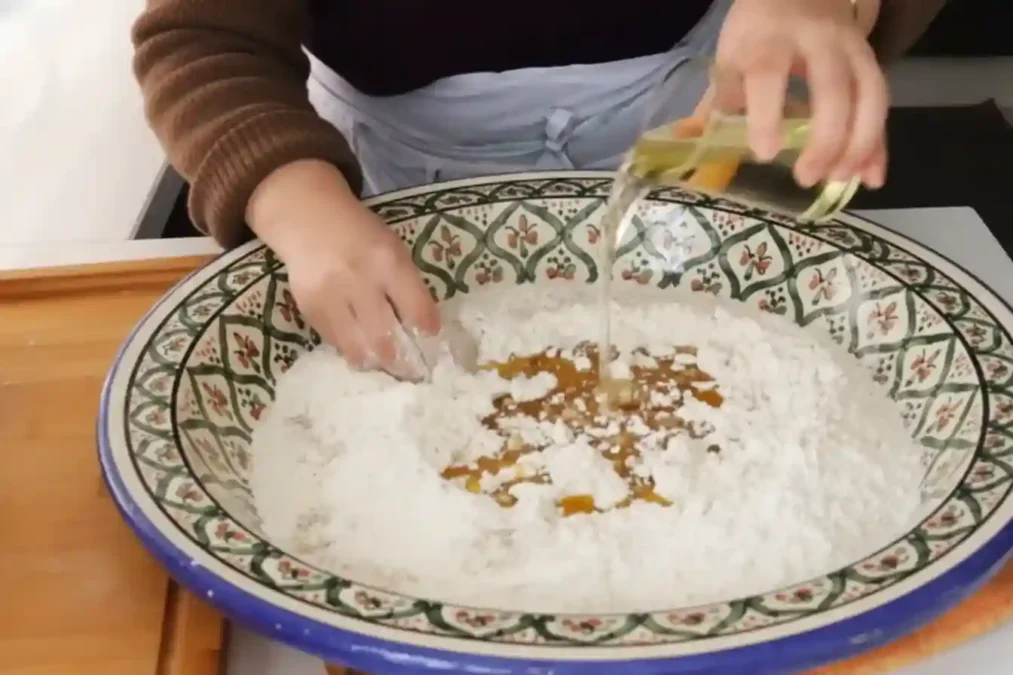 Préparation de la pâte à chebakia marocaine dans un grand plat traditionnel