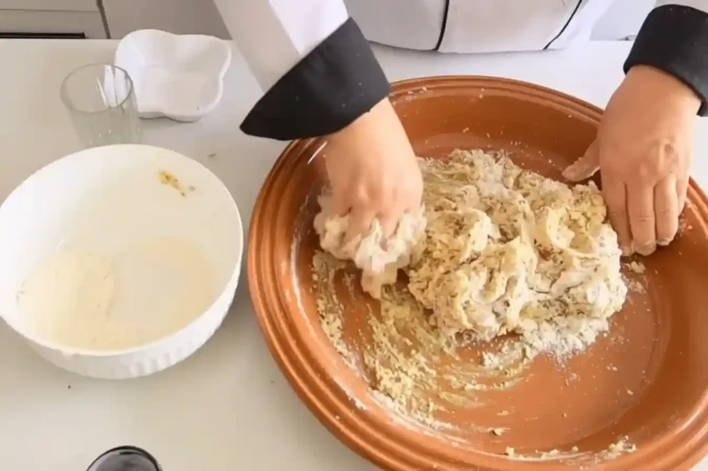 Pétrissage de la pâte à fekkas dans un grand plat en terre cuite